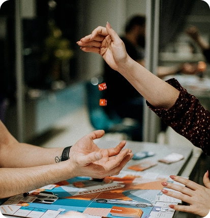 O jogador lança os dados vermelhos por cima do tabuleiro do jogo de mesa